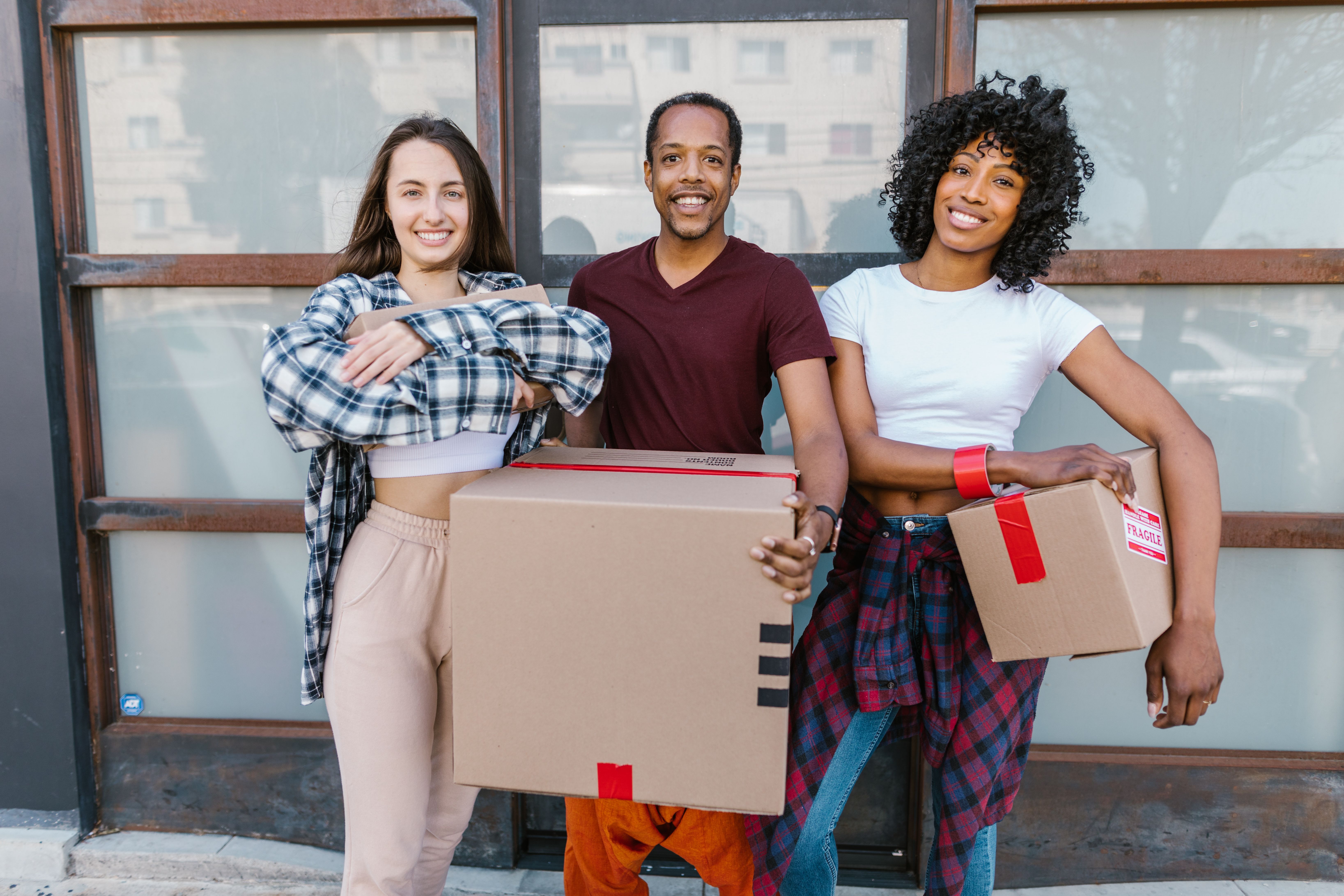 Happy tenants pose with cardboard moving boxes