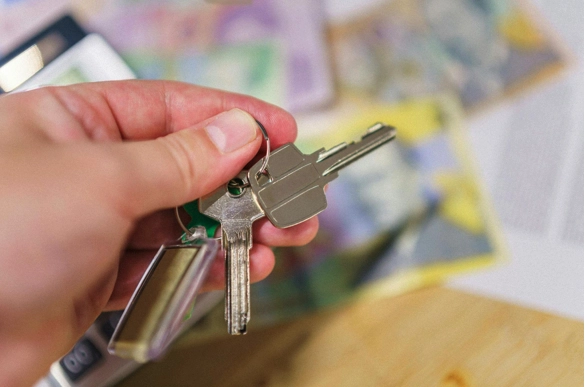 a hand holding a keychain of keys.