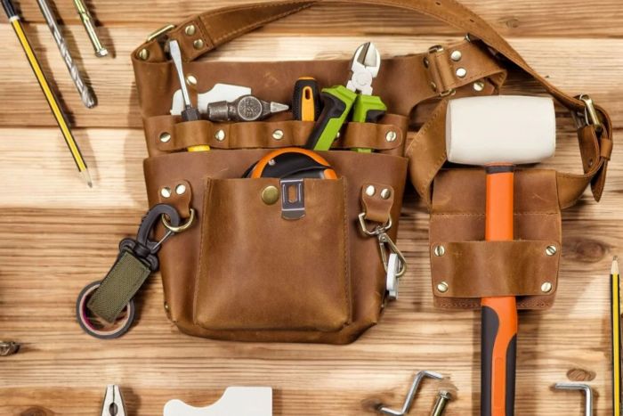 Toolbelt with basic home improvement hand-tools like a rubber mallet, tape measure, side-cutters, and screwdrivers