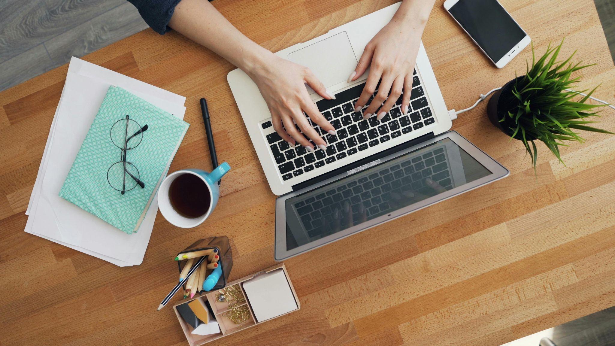 Overhead view of someone typing on a laptop