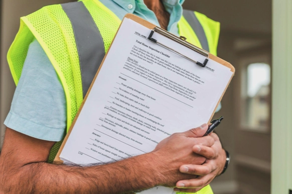 a construction worker holding a clipboard and pen.